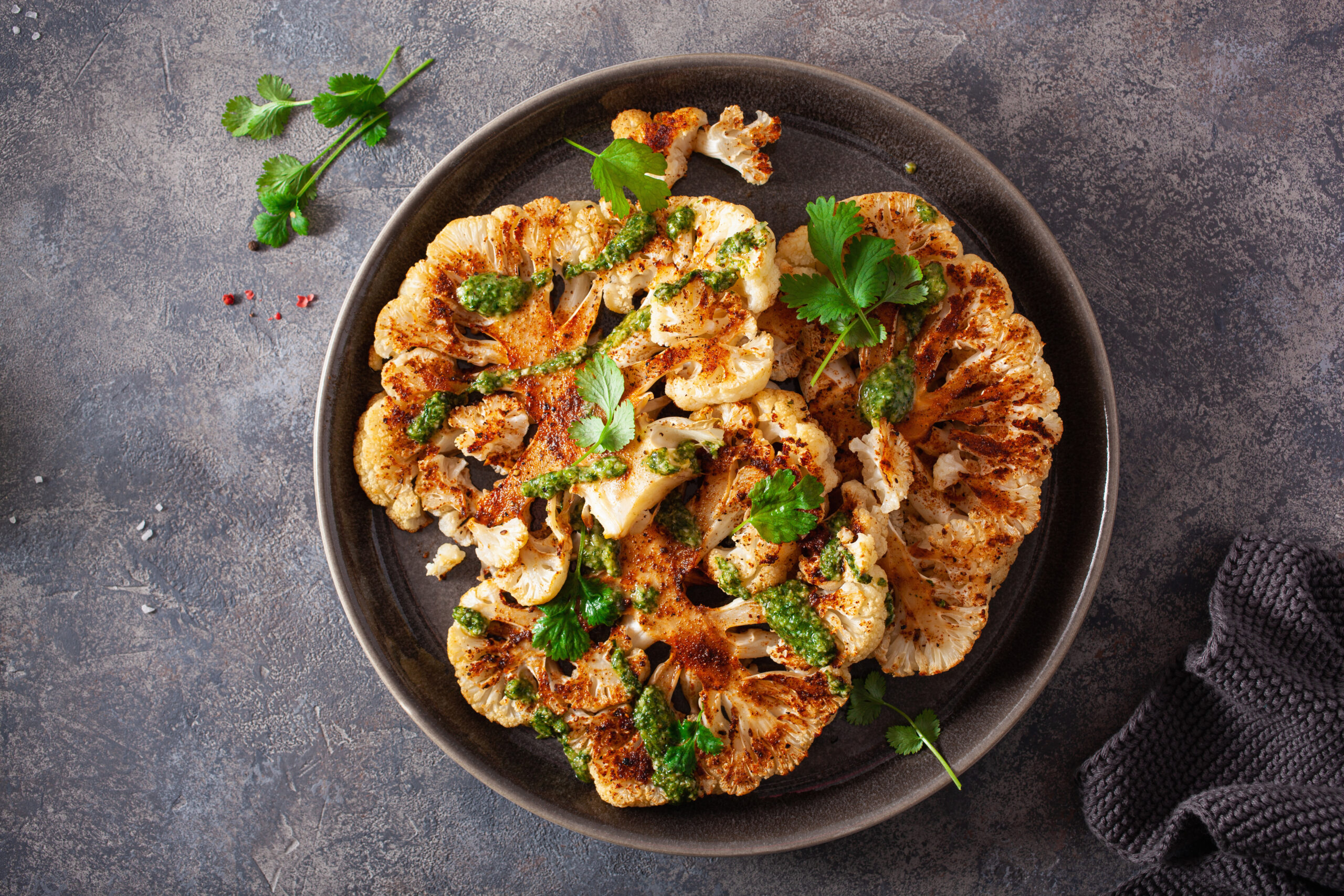 cauliflower steaks with herb sauce and spice. plant based meat substitute